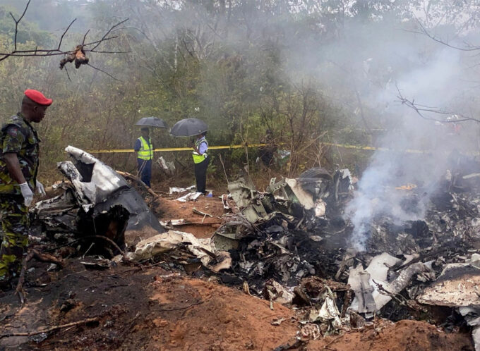 Kenyan security officials secure the wreckage of an aircraft which crashed with 11 people onboard.