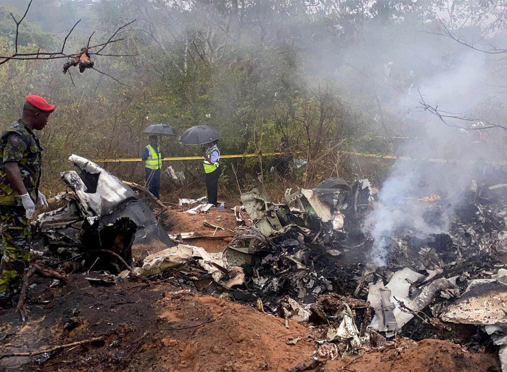 Kenyan security officials secure the wreckage of an aircraft which crashed with 11 people onboard.