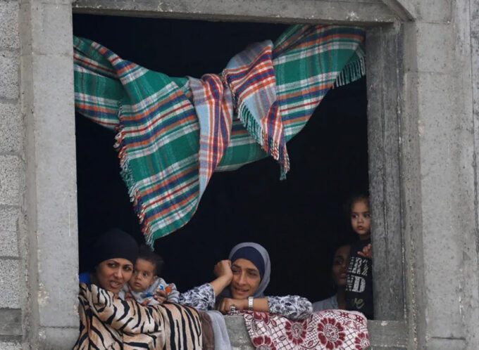 Palestinian women and children look out from a window after US President Donald Trump announced that Israel and Hamas agreed on the first phase of a Gaza ceasefire, in central Gaza, 9 October 2025.